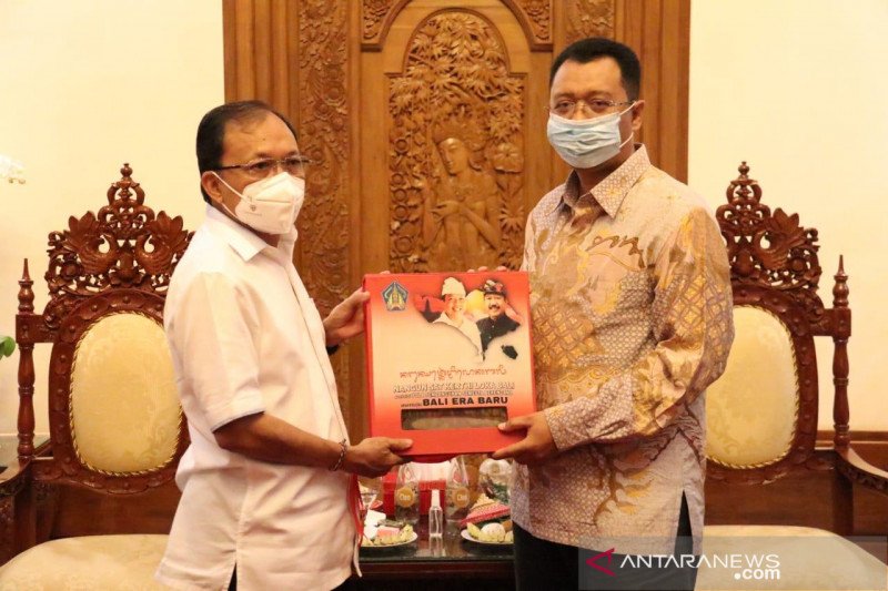 Gubernur Bali Wayan Koster saat menyerahkan kenang-kenangan kepada Gubernur NTB Zulkieflimansyah di Denpasar (Antaranews Bali/HO-Pemprov Bali/2020)

