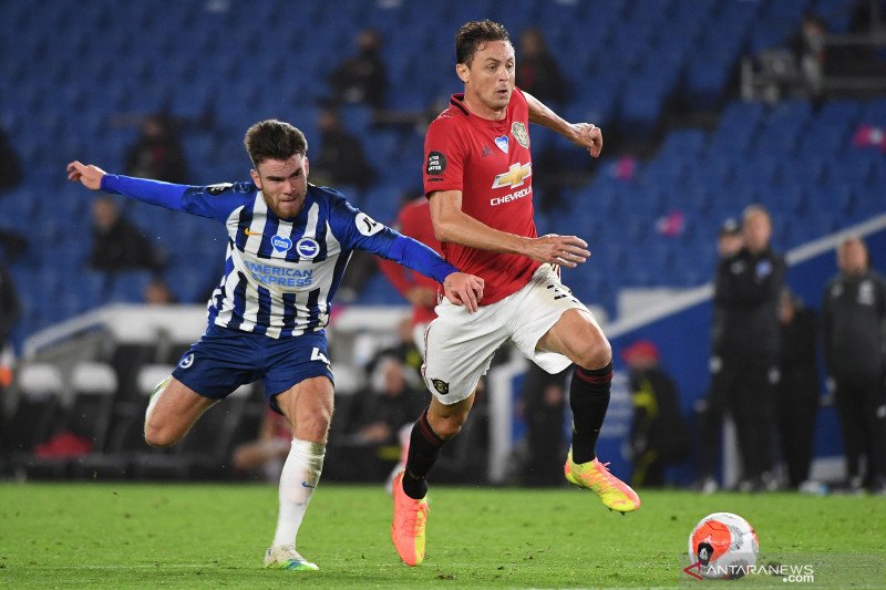 Pesepak bola Manchester United Nemanja Matic (kanan) membawa bola dijaga pesepak bola Brighton & Hove Albion Aaron Connolly (kiri) dalam laga pekan ke-32 Liga Inggris, dalam pertandingan tertutup tanpa kehadiran penonton karena masih mewabahnya virus Coro
