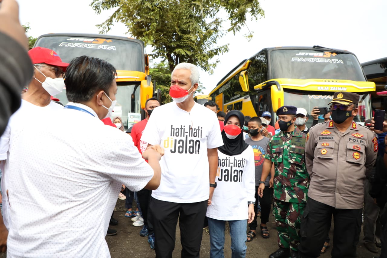 Gubernur Jateng Ganjar Pranowo kembali muncul dengan kaos unik ketika melepas ribuan pemudik Jateng dari Taman Mini Indonesia Indah, Kamis (28/4/2022). Ganjar  didampingi istrinya, Siti Atikoh mengenakan kaos oblong putih bertuliskan “Hati-Hati Di Jalan”.