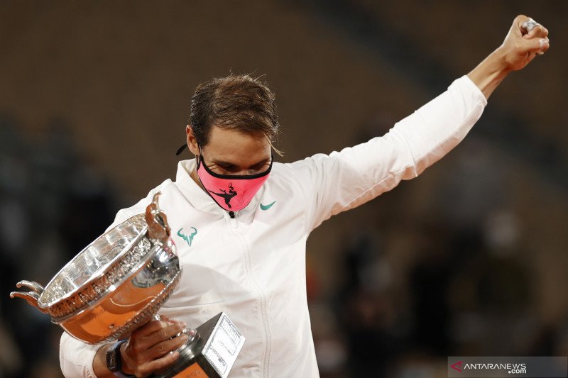 Petenis Spanyol Rafael Nadal melakukan selebrasi dengan mengangkat piala dan mengepalkan tangannya setelah berhasil keluar sebagai juara Tunggl Putera Turnamen Tenis French Open 2020, di Roland Garros, Paris, Prancis, Minggu (11/10/2020). Nadal menjadi ju