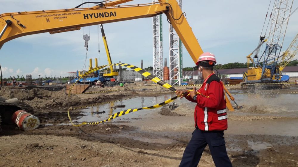 Pegawai PT Adhi Karya di lokasi proyek pembangunan gedung UINSA saat pipa PDAM jebol terkena tiang pancang, Minggu (17/5). (FOTO HMP/PRAS PRASETYO)