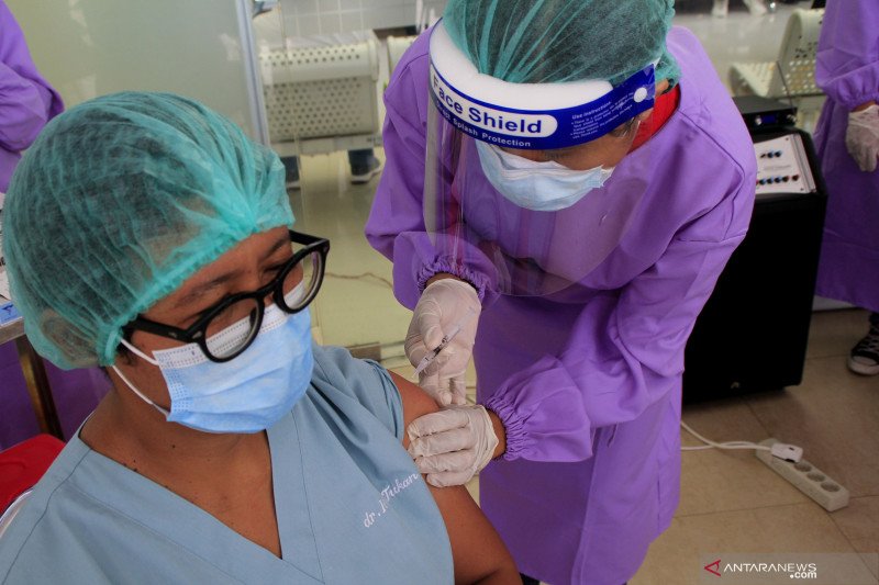 Seorang dokter menyuntikan cairan vaksin ke tubuh seorang tenaga kesehatan di RSUD SK Lerik Kota Kupang, NTT Jumat (15/01/2021). Sebanyak 2000 tenaga kesehatan di Kota Kupang akan menerima vaksin COVID-19 tahap pertama.ANTARA FOTO/Kornelis Kaha. (Antara F