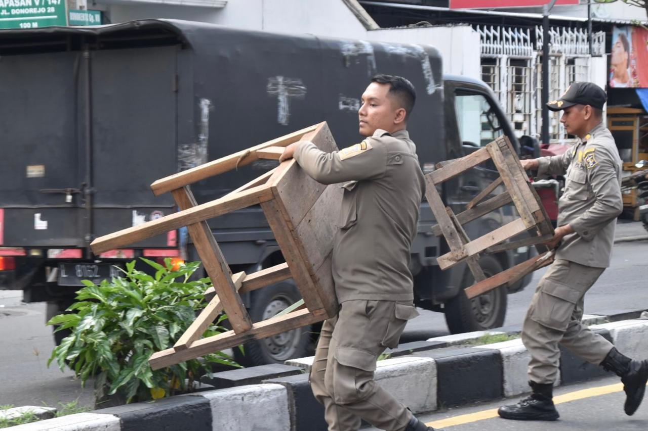 Satpol PP Kota Surabaya melakukan penertiban Pedagang Kaki Lima (PKL) serta lapak-lapak kayu yang berada diatas pedestrian di sepanjang Jalan Kenjeran hingga Ngaglik 