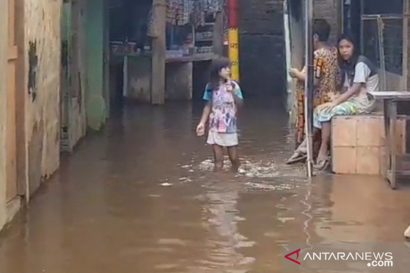 Warga Kebon Pala melintas di genangan air saat terjadi luapan Kali Ciliwung, Kamis (12/11/2020). (ANTARA/Andi Firdaus).

