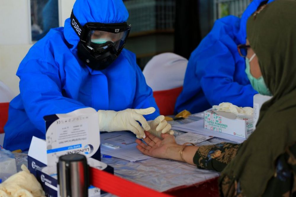 Petugas medis dari Badan Intelijen Negara (BIN) melakukan rapid test dan swab gratis kepada warga di Jalan Gresik PPI, Kecamatan Krembangan, Kota Surabaya, Sabtu (30/5/2020). (FOTO ANTARA/HO/Humas Pemkot Surabaya)