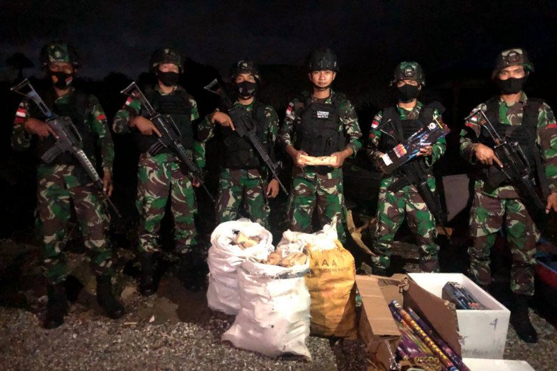 Sejumlah personel Satuan Tugas Pengamanan Perbatasan (Satgas Pamtas) Yonif RK 744/SBY berpose bersama barang bukti berupa kayu cendana dan kembang api yang digagalkan dalam upaya penyelundupan di Pantai Atapupu, Kabupaten Belu, Nusa Tenggara Timur pada Ra