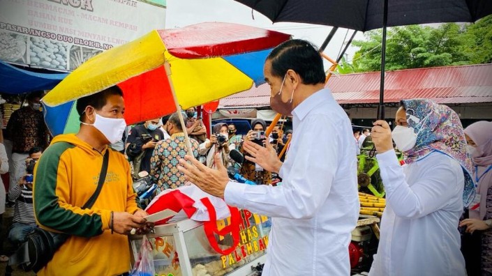 Presiden Joko Widodo memberikan Bantuan Langsung Tunai (BLT) Minyak Goreng kepada sejumlah pedagang kecil dan penerima di Pasar Rakyat Angso Duo Baru, Kota Jambi, Kamis, 7 April 2022. Foto: BPMI Setpres/Laily Rachev
