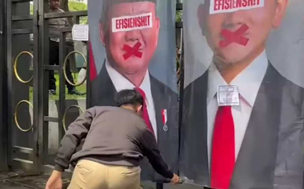 banner foto Prabowo-Gibran dipasang di pagar DPRD Kota Malang. Dalam foto tersebut, tampak mata Prabowo dan Gibran dicoret dengan kata 'EFISIENSH!T' lalu mulutnya disilang oleh pengunjuk rasa. 

