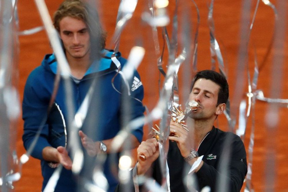 GANTI VIRTUAL: Petenis Serbia Novak Djokovic merayakan kemenangan dengan mencium tropi setelah mengalahkan petenis Yunani Stefanos Tsitsipas pada pertandingan final kejuaraan tenis ATP 1000 Madrid Open di The Caja Magica, Madrid, Spanyol, Minggu (12/5/201