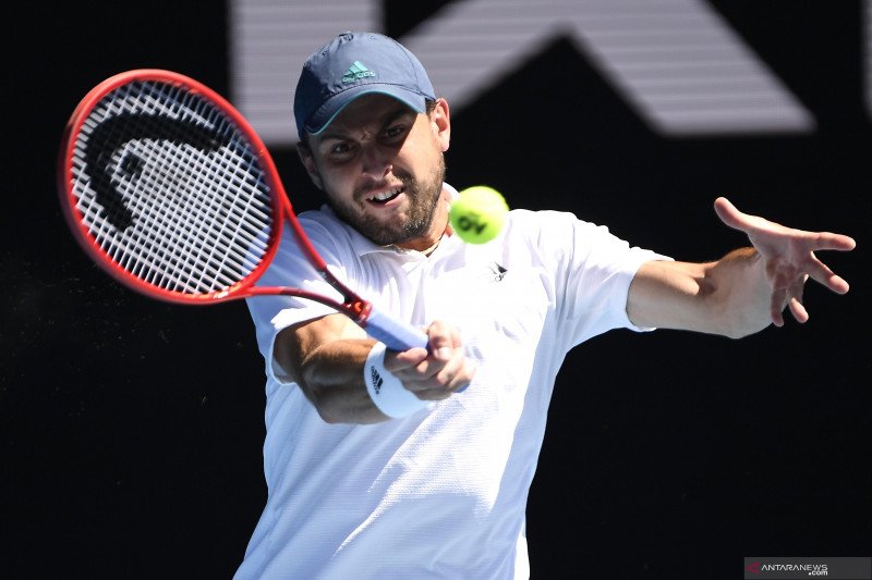 Petenis Rusia Aslan Karatsev mengembalikan bola ke arah lawannya petenis Bulgaria Grigor Dimitro dalam laga perempat final Turnamen Tenis Australian Open, di Melbourne Park, Melbourne, Australia, Selasa (16/2//2021). Karatsev melaju ke semi final setelah 