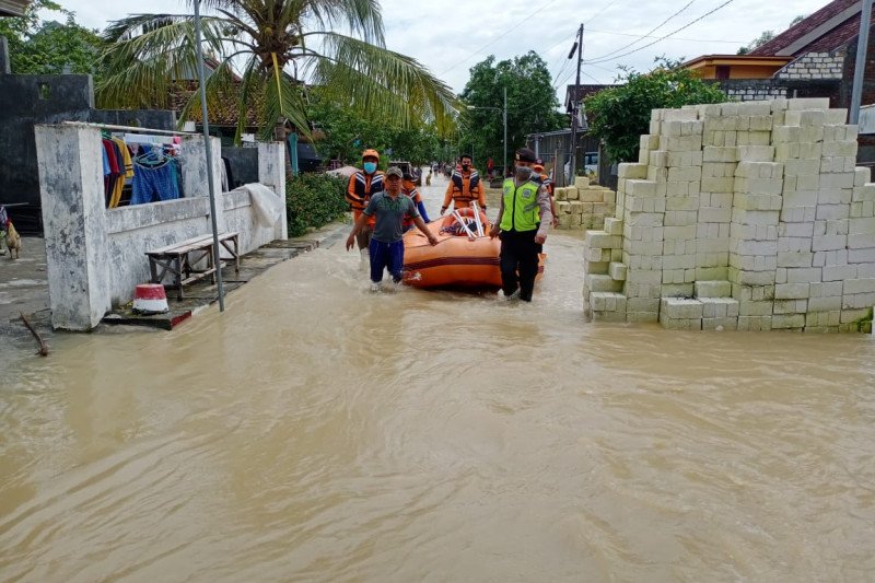 Petugas melakukan evakuasi dengan perahu karet dalam banjir di Kabupaten Gresik, Jatim, Minggu (13/12) (Antara Jatim/H.O-AM)