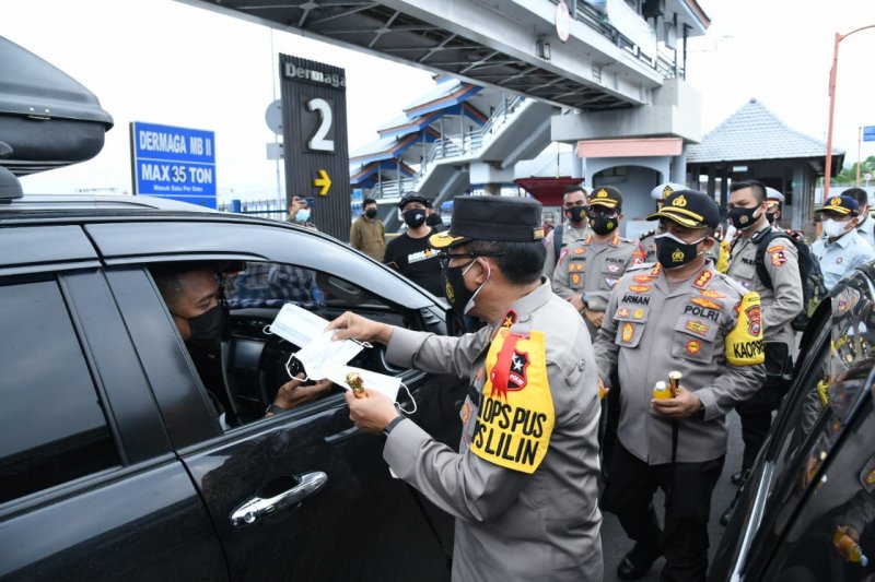 Kepala Korps Lalu Lintas Kepolisia Indonesia, Inspektur Jenderal Polisi Istiono (tengah), membagikan masker kepada pengemudi kendaraan yang melintasi Pelabuhan Ketapang, Banyuwangi, Jawa Timur, Minggu (27/12/2020). ANTARA/ HO-NTMC Polri

