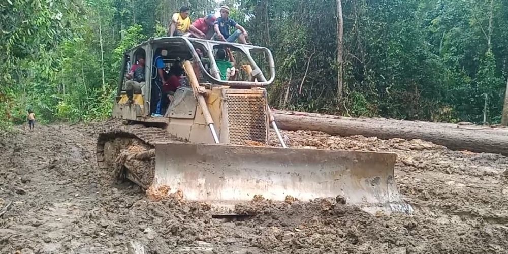 ALAT BERAT: Warga menduduki alat berat yang dipakai untuk membabat kayu (Foto: Cho)