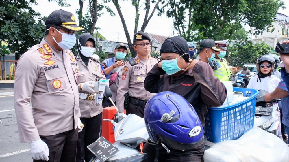 Kapolresta Sidoarjo Kombes Pol. Sumardji memberikan masker kepada pengendara motor. ( foto : Bil/hmp)
