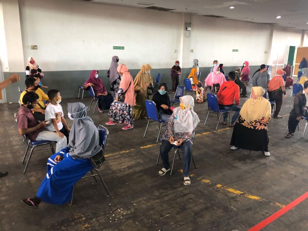 Petugas Kepolisian memberikan hand sanitizer kepada masyarakat yang antri sembako di jatim expo. ( foto:ris/hmp)