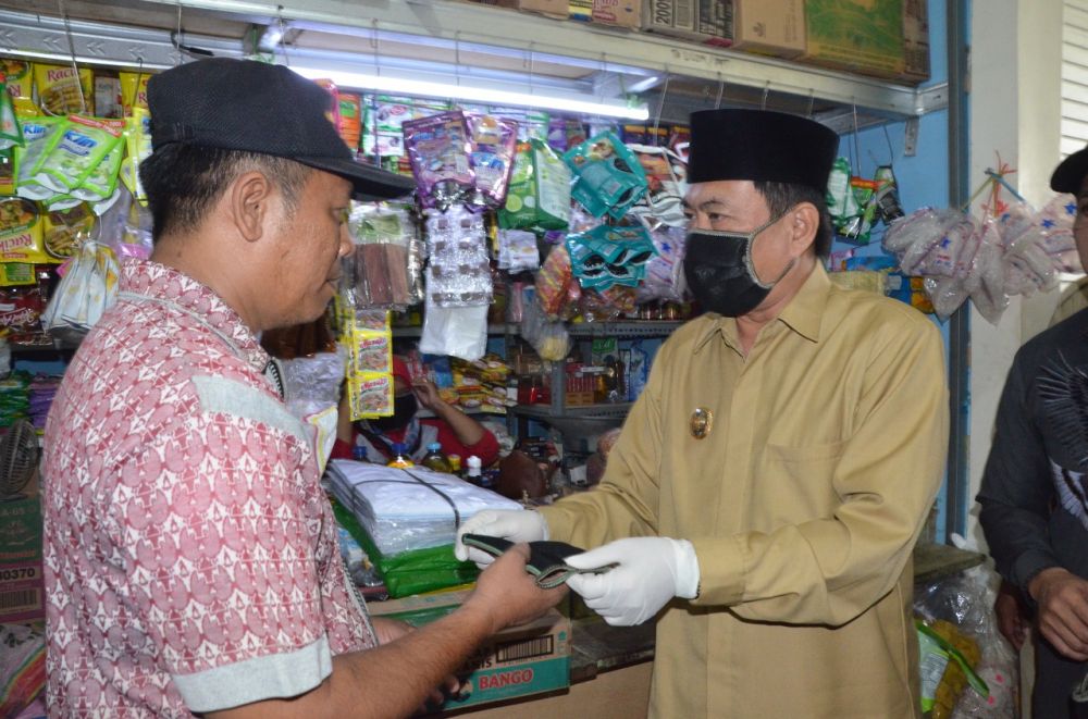 Wakil Bupati Nur Ahmad  Syaiffudin saat membagi masker dan sembako di pasar Krian, Selasa (21/4). (foto: bil/hmp)