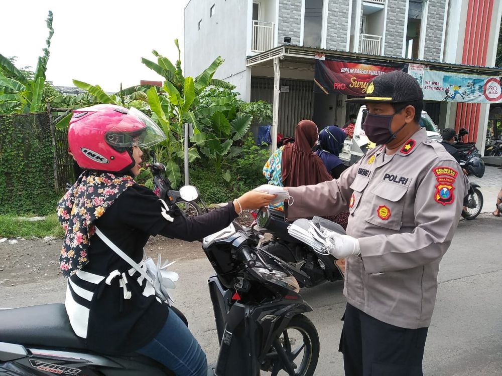 Kapolsek Balongbendo Kompol Sugeng Purwanto saat memberikan masker kepada pengendara. ( foto: bil/hmp)