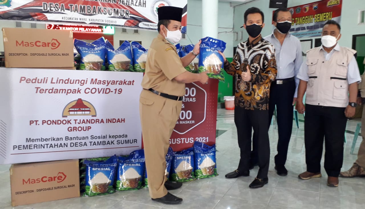 Executive Founder and CEO PT. Pondok Tjandra Indah Group, Tjandra  Sugiharto  secara simbolis memberikan bantuan 1.000 sak beras  dan 200 pak masker kepada Desa Tambak Sumur Kecamatan Waru Sidoarjo, Senin (23/8). foto : prasetyo