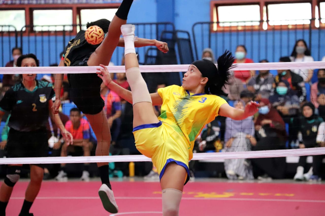 Atlet sepak takraw putri Jawa Timur Mega Citra (kanan) menendang bola dan coba dihalau atlet sepak takraw putri Papua Dina (2) dalam pertandingan sepak takraw putri PON Papua di GOR Trikora UnIversitas Cenderawasih, Jayapura, Papua, Selasa (28/9/2021).
f