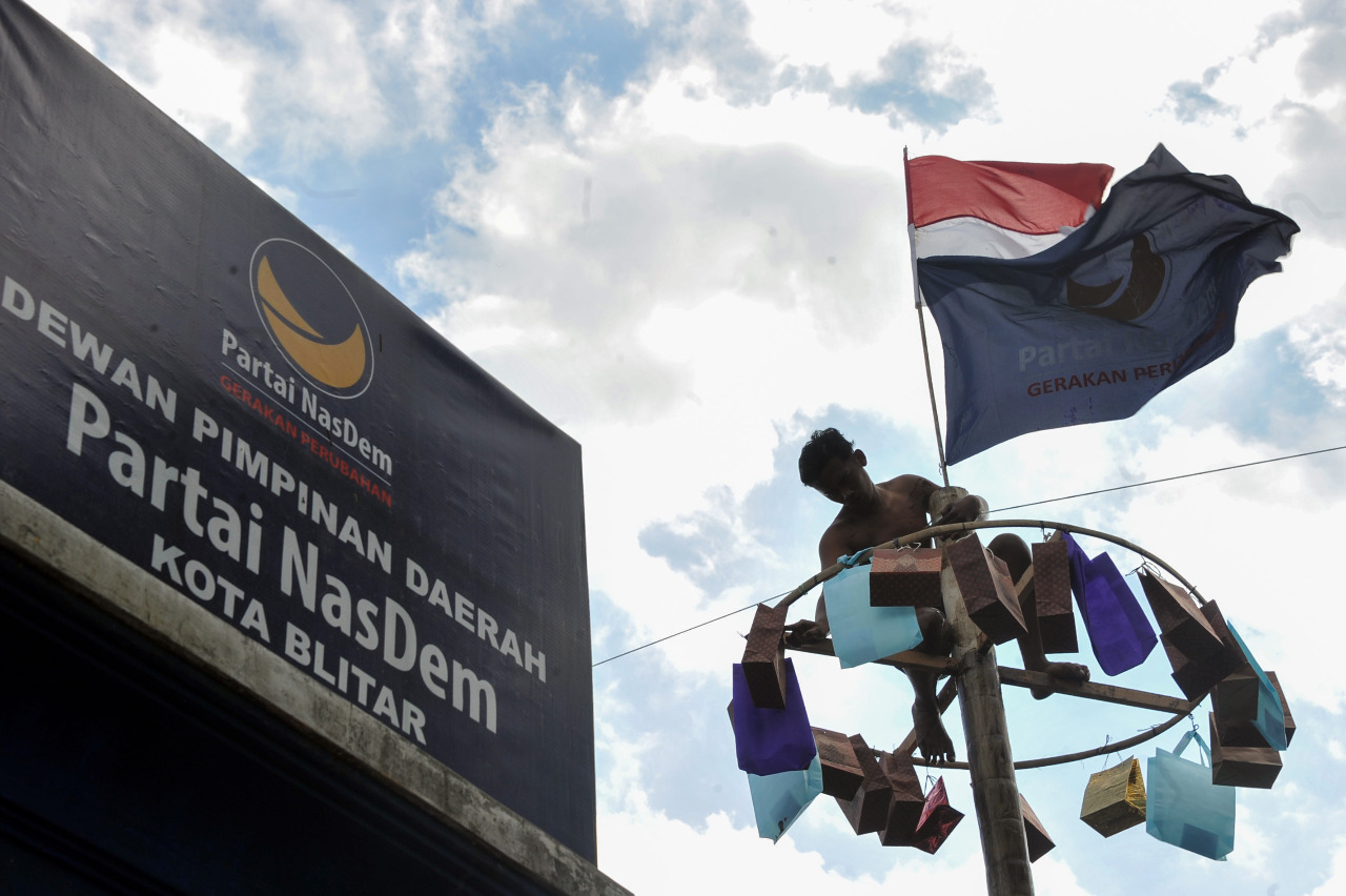 Kaum pria dewasa berkelompok mengikuti panjat pinang yang diselenggarakan oleh Partai NasDem dalam rangka memperingati HUT ke 77 Republik Indonesia tahun 2022,  di kantor DPD Partai NasDem Kota Blitar, Rabu (17/8/2022).