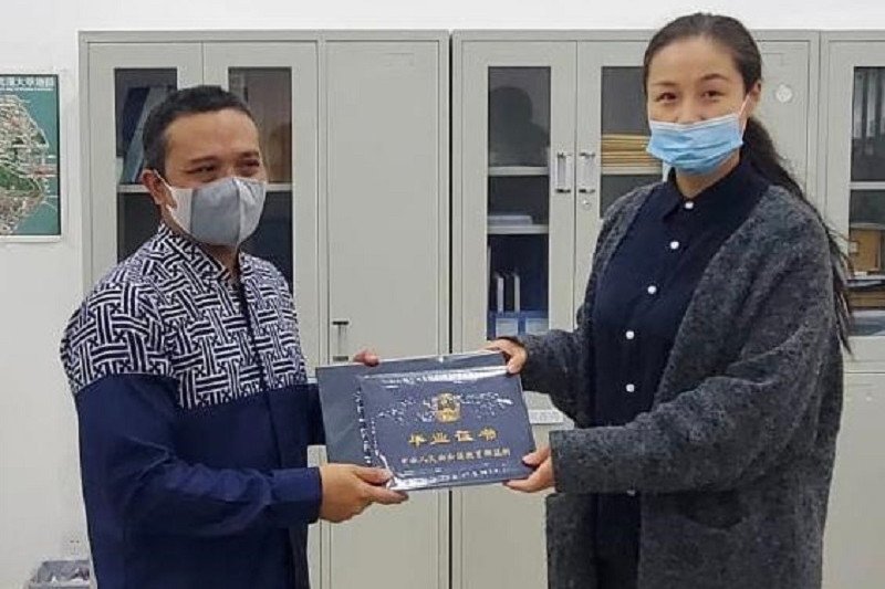Atase Pendidikan dan Kebudayaan KBRI Beijing Yaya Sutarya menerima ijazah mahasiswa asal Indonesia dari Gao Ying selaku Kepala Administrasi Wuhan University School of International Education (WUSIE) di Kota Wuhan, Provinsi Hubei, China, Senin (2/11). (ANT