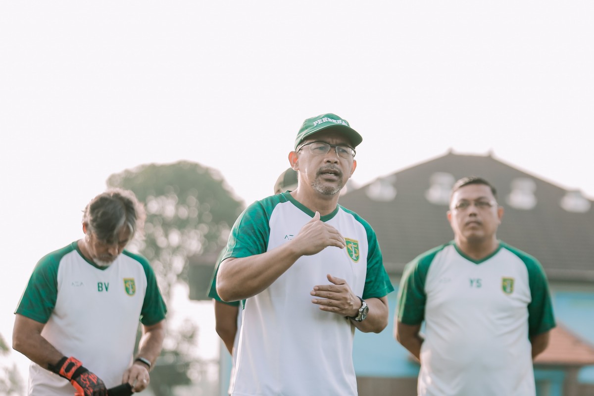 Aji Santoso memberikan instruksi kepada pemain Persebaya sebelum menjalani latihan.