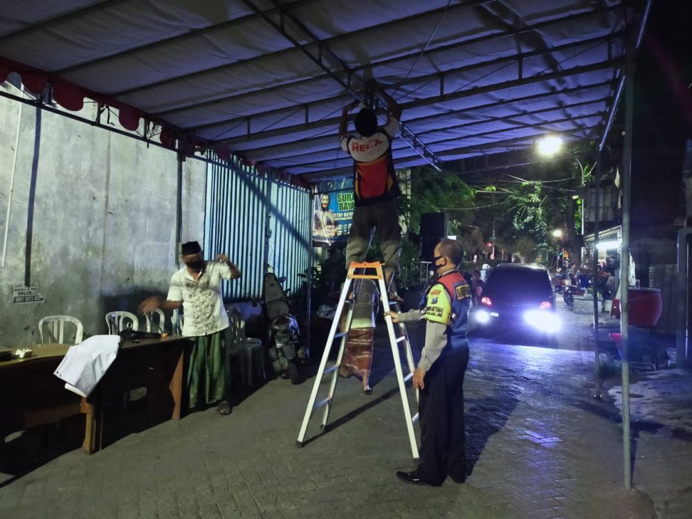 Warga dan aparat kepolisian saat bergotong royong menyiapkan pembentukan Satgas Kampung Tangguh Panjang Jiwo, Rabu (3/6).
