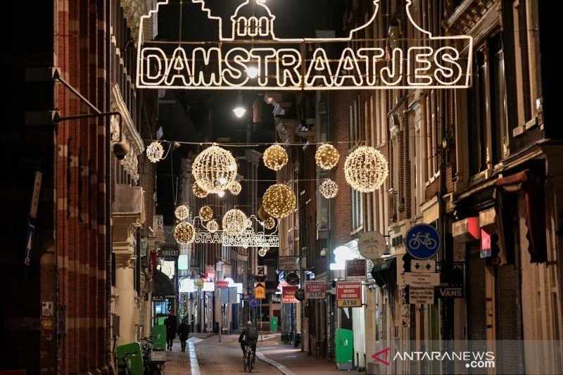 Seorang warga mengendarai sepeda selama jam malam saat wabah virus corona (COVID-19) di Amsterdam, Belanda, Sabtu (23/1/2021). (REUTERS/Piroschka Van De Wouw/HP/sa)

