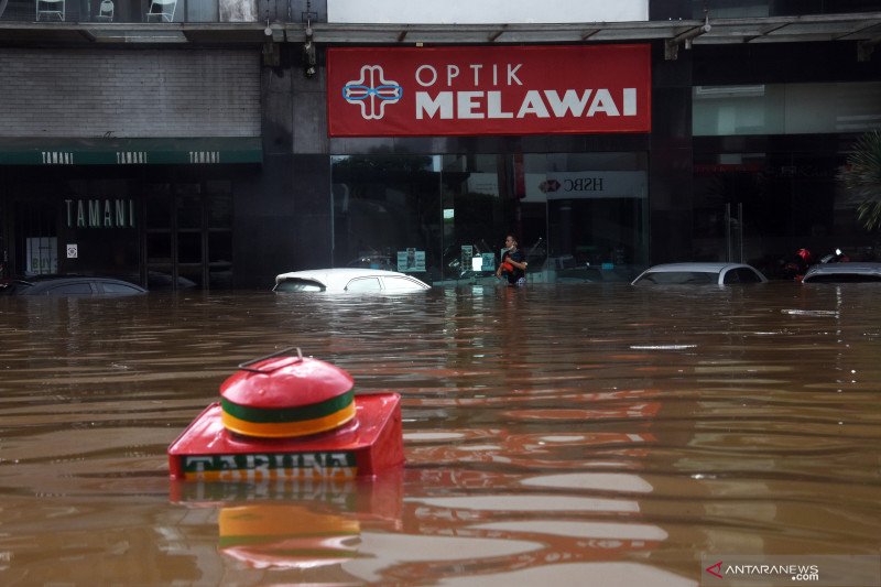 Warga berjalan melewati banjir di kawasan Kemang, Jakarta Selatan, Sabtu (20/2/2021). Banjir yang terjadi akibat curah hujan tinggi serta drainase yang buruk membuat kawasan Kemang banjir setinggi 1,5 meter. ANTARA FOTO/Indrianto Eko Suwarso/wsj.

