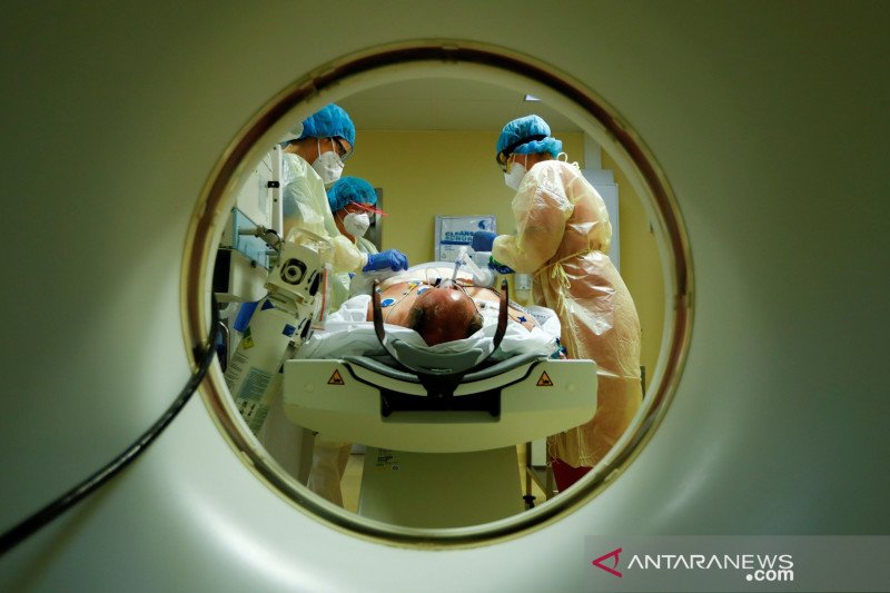 Petugas medis dengan alat pelindung diri merawat pasien yang terinfeksi virus corona (COVID-19) dengan komputer tomograf di Unit Perawatan Intensif (ICU) di rumah sakit Havelhoehe, Berlin, Jerman, Jumat (30/10/2020). ANTARA FOTO/REUTERS/Fabrizio Bensch/HP