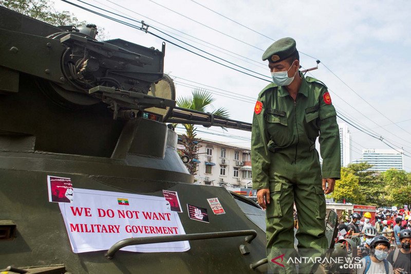 
Seorang tentara melihat spanduk yang dipasang di kendaraan lapis baja di depan Bank Sentral Myanmar saat aksi protes berlangsung di Yangon, Myanmar, Senin (15/2/2021), untuk menentang kudeta militer. ANTARA FOTO/REUTERS/Stringer/AWW/djo
