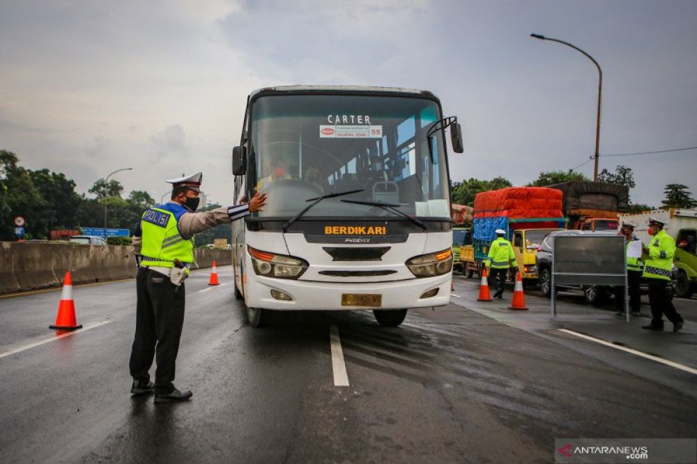 Petugas kepolisian mengarahkan bus ke pintu keluar Tol Bitung, Kabupaten Tangerang, Banten, Jumat (24/4/2020). ANTARA FOTO/Fauzan/wsj.