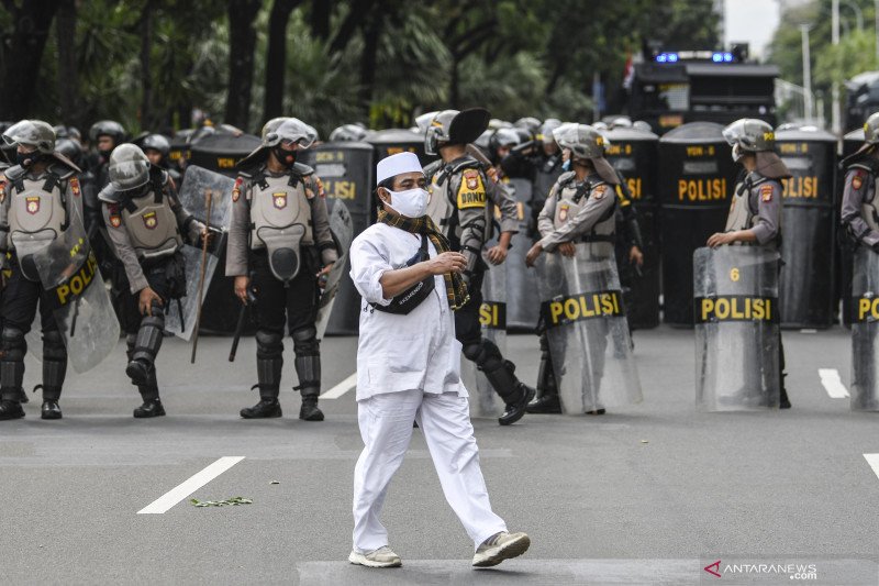 Seorang pengunjuk rasa aksi demonstrasi 1812 berjalan saat membubarkan diri, di kawasan Medan Merdeka Selatan, Jakarta, Jumat (18/12/2020). Kepolisian membubarkan paksa massa aksi demonstrasi dikarenakan angka penyebaran COVID-19 masih tinggi di wilayah J