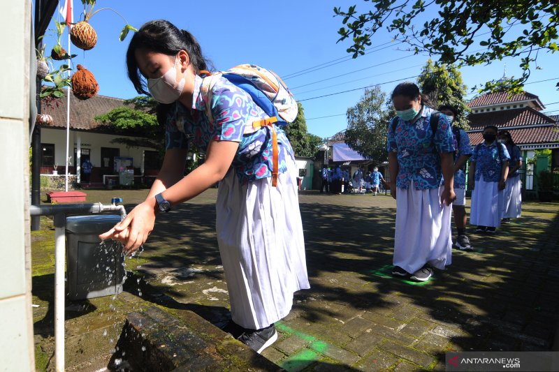 Sejumlah siswa antre mencuci tangan sebelum masuk ruang kelas di SD Negeri Dukuh 1, Salatiga, Jawa Tengah, Rabu (17/3/2021). Simulasi protokol kesehatan COVID-19 di sekolah tersebut tersebut bertujuan untuk memperkuat kebiasaan baru di lingkungan sekolah 