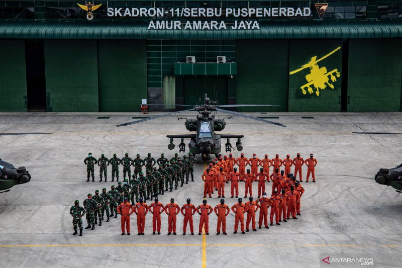 Prajurit TNI AD dari Skadron-11/Serbu Puspenerbad yang dipimpin oleh Dandron-11/Serbu Letkol Cpn Andy Pranoto membentuk formasi angka 75 dikelilingi sejumlah helikopter AH-64E Apache di kawasan Pangkalan Udara Utama TNI AD (Lanumad) Ahmad Yani, Semarang, 