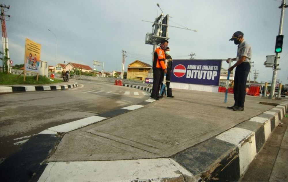 DITUTUP: Petugas memasang pembatas jalan saat penutupan ke arah Jakarta di pintu keluar tol Adiwerna, Kabupaten Tegal, Jawa Tengah, Selasa (26/5/2020). | ANTARA