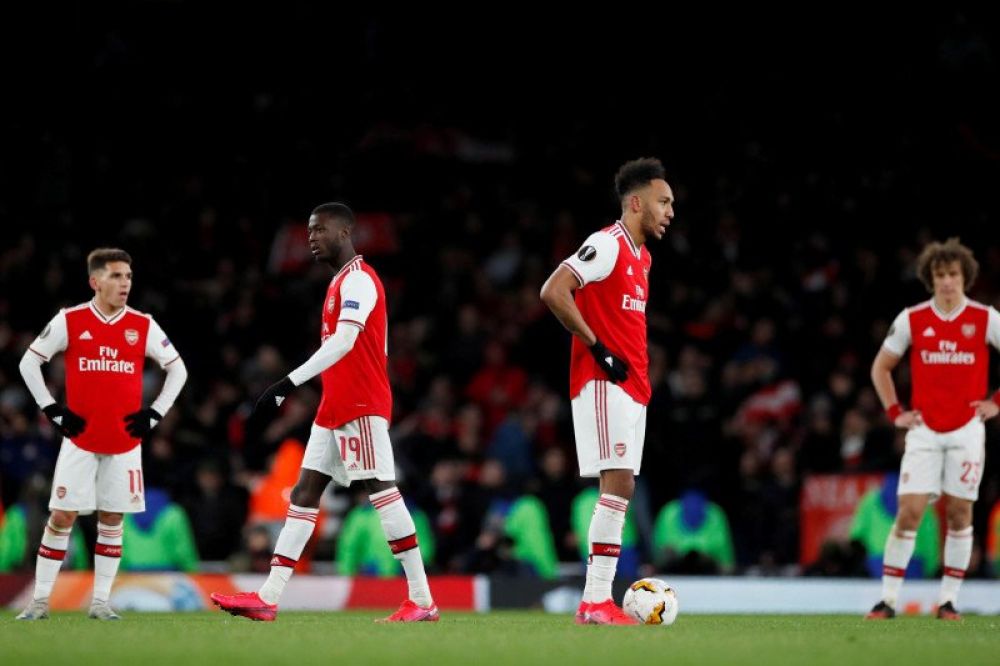 Pemain sepakbola Arsenal Pierre-Emerick Aubameyang, Nicolas Pepe dan rekan satu tim berdiri diam setelah kebobolan gol untuk yang kedua kali saat melawan Olympiacos dalam Liga Eropa di Emirates Stadium, London, Inggris, Kamis (27/2/2020). (Action Images v