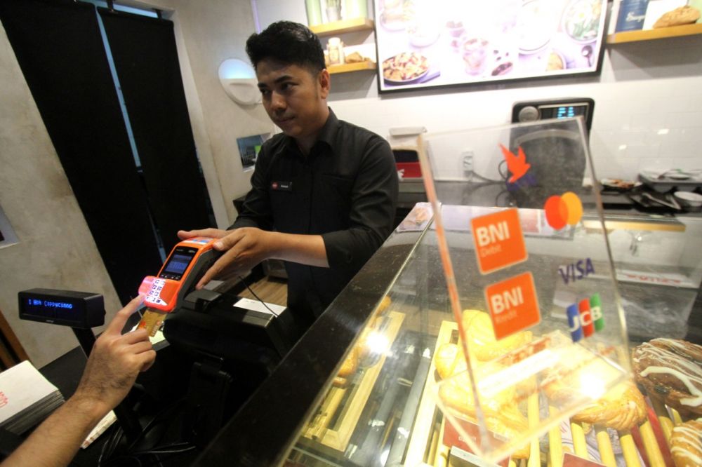 Salah satu transaksi di gerai makanan menggunakan kartu kredit BNI. IST