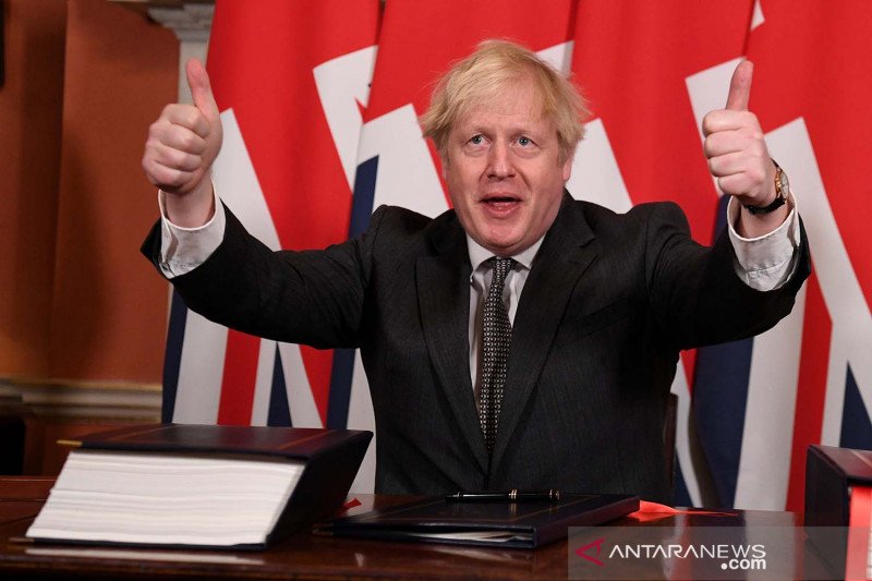 Perdana Menteri Britain Boris Johnson mengacungkan dua jempol setelah menandatangani kesepakatan dagang Brexit dengan Uni Eropa di 10 Downing Street di London, Britain, Rabu (30/12/2020). Leon Neal/Pool via REUTERS/aww/cfo (REUTERS/POOL)
