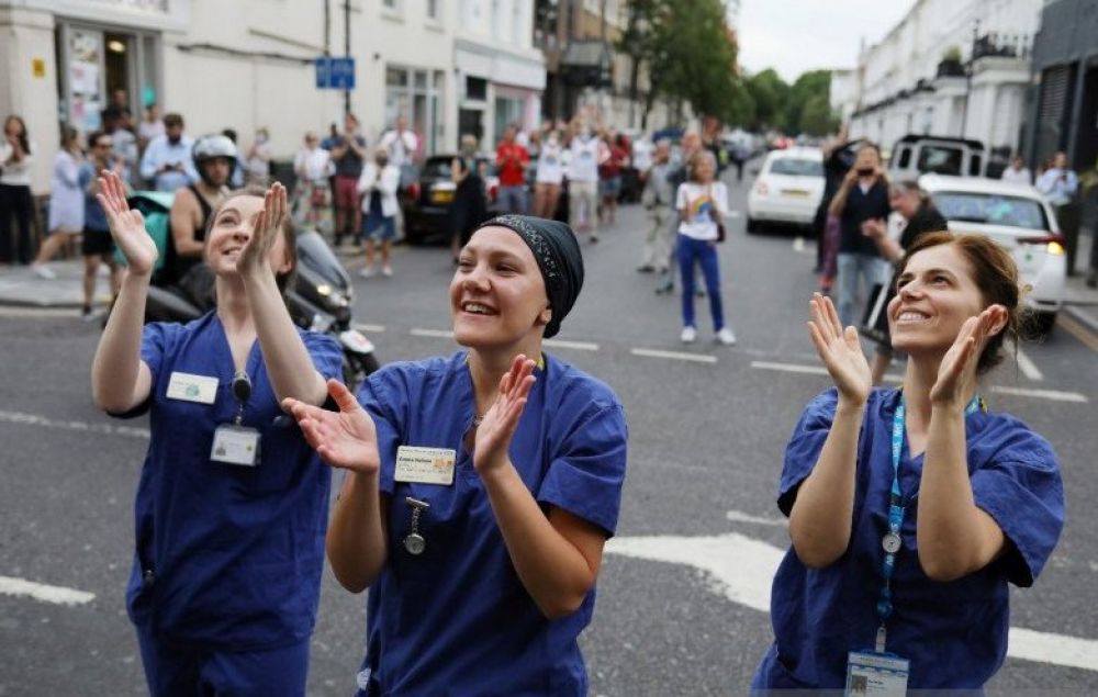 Anggota masyarakat dan petugas NHS bertepuk tangan di Rumah Sakit Chelsea and Westminster saat kampanye "Clap for Our Carers" sebagai dukungan kepada NHS, menyusul penyebaran penyakit virus korona (COVID-19) di London, Britain, Kamis (21/5/2020). REUTERS/