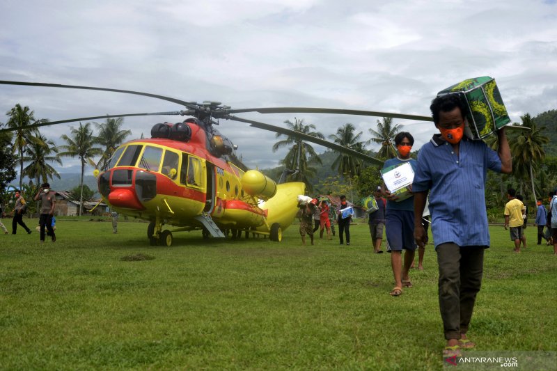 Sejumlah warga korban gempa bumi memindahkan bantuan logistik dari helikopter Badan Nasional Penanggulangan Bencana (BNPB) yang mendarat di Kecamatan Malunda, Kabupaten Majene, Sulawesi Barat, Rabu (20/1/2021). ANTARA FOTO/Abriawan Abhe/wsj.

