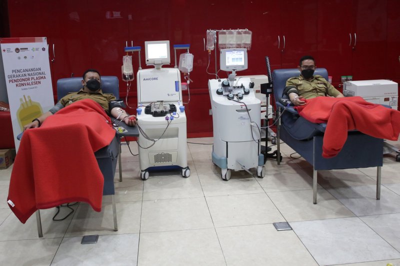 Kabag Humas Pemkot Surabaya Febriadhitya Prajatara dan Camat Bubutan Eko Kurniawan Purnomo saat mendonorkan plasma konvalesennya di kantor PMI Cabang Surabaya, Senin (15/2/2021). (FOTO ANTARA/HO-Humas Pemkot Surabaya)
