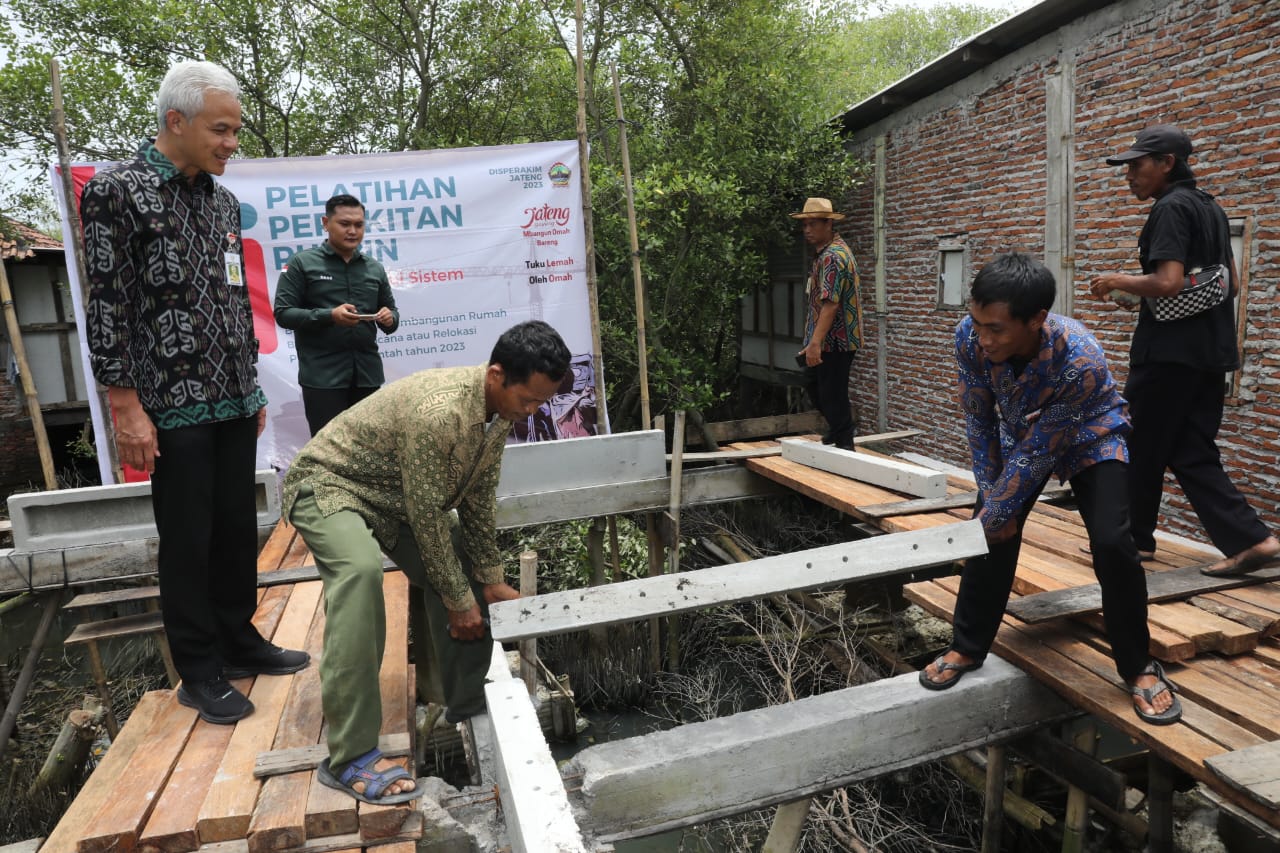 Gubernur Jawa Tengah Ganjar Pranowo meninjau program bantuan rumah sistem panel instan (ruspin) untuk korban bencana rob di Desa Bedono, Kecamatan, Sayung, Kabupaten Demak, Selasa (14/3/2023).