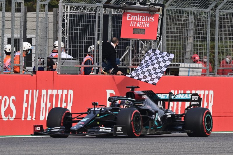 Pebalap tim Mercedes Lewis Hamilton melintasi garis finis dan menjuarai Grand Prix Emilia Romagna di Sirkuit Imola, Italia. (1/11/2020). Pool via Reuters/Miguel Medina

