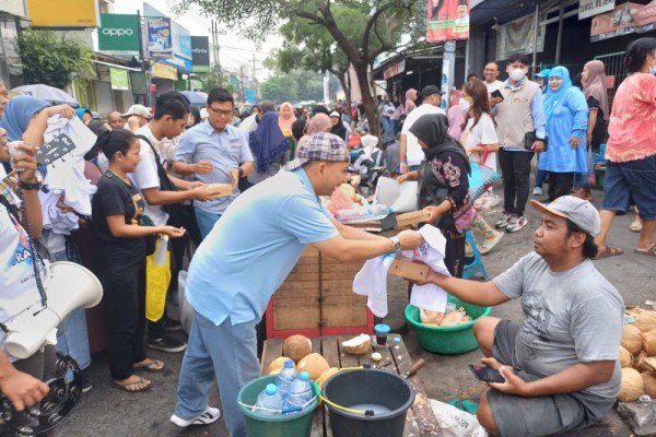 Tim Kampanye Daerah (TKD) Jawa Timur Prabowo-Gibran membagikan 2.000 nasi kotak serta kaus dan kalender kepada masyarakat, di Pasar Petemon, Surabaya, Minggu (7/1/2024)