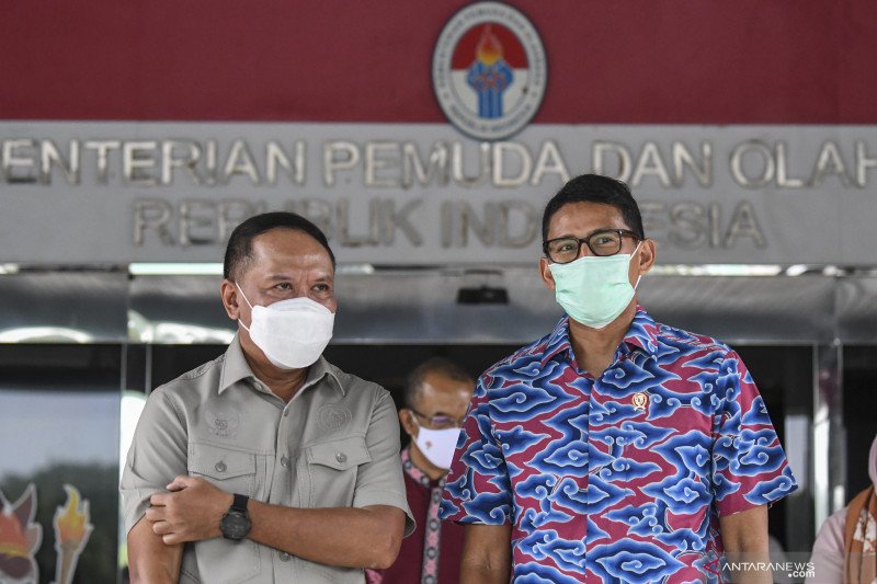 Menpora Zainudin Amali (kiri) berbincang dengan Menparekraf Sandiaga Salahuddin Uno (kanan) usai pertemuan membahas tentang kerjasama pengembangan 'sport tourism' di Kantor Kemenpora, Jakarta, Selasa (5/1/2021). . ANTARA FOTO/M Risyal Hidayat/rwa. (ANTARA
