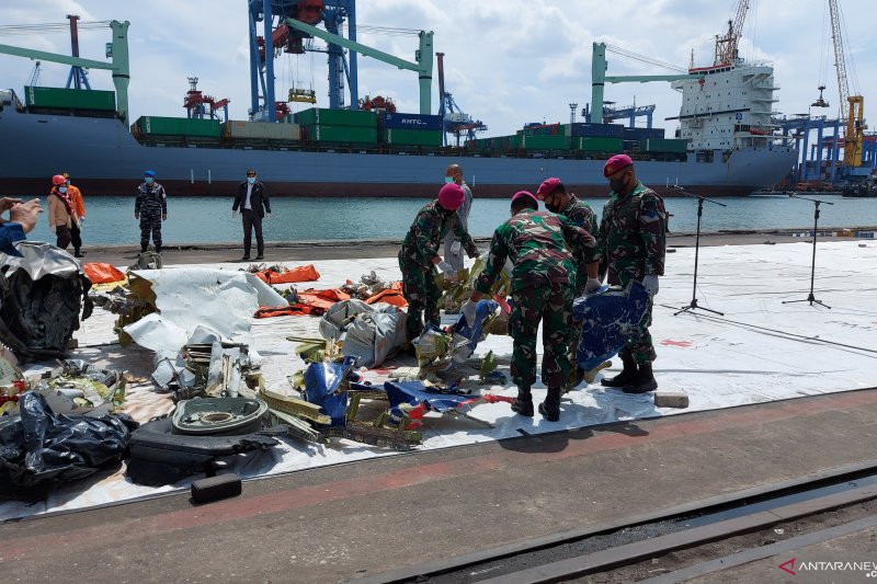 Personel Marinir TNI AL menyusun serpihan pesawat Sriwijaya Air SJ 182 yang berhasil dievakuasi dan dikumpulkan di Posko SAR Terpadu Jakarta International Container Terminal (JICT) 2 Tanjung Priok, Jakarta Utara, Sabtu (16/1/2021). ANTARA/Fianda Sjofjan R