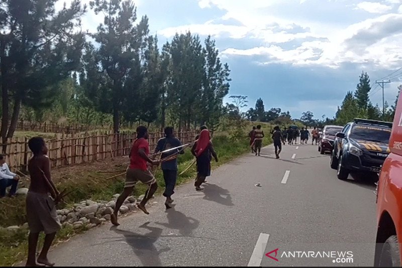 Warga yang terkesan tidak peduli keberadaan polisi dan terus berlari ke arah tempat yang diduga akan datang kelompok lawan. (ANTARA/Marius Frisson Yewun)
