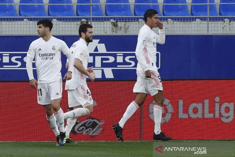Bek tengah Real Madrid Raphael Varane (kanan) melakukan selebrasi bersama rekan-rekannya seusai mencetak gol pembalik keadaan atas Huesca dalam lanjutan Liga Spanyol di Stadion El Alcoraz, Huesca, Spanyol, Sabtu (6/2/2021) waktu setempat. (ANTARA/REUTERS/