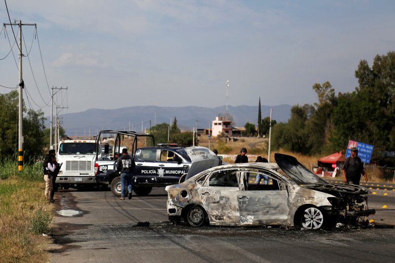 Sejumlah polisi berjaga-jaga di dekat rongsokan sebuah mobil yang terbakar , dalam operasi memerangi gang narkoba oleh jaringan kartel di Meksiko (ANTARA/REUTERS/Sergio Maldonado/File Photo/TM (REUTERS/SERGIO MALDONADO)

